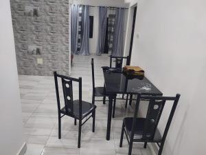 a dining room with a black table and chairs at FassoImmoPrestige in Tambacounda