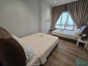 Una habitación de hotel con dos camas y una ventana. en The Octagon -The City Centre Signature Suite in Ipoh, en Ipoh 40 fotos más