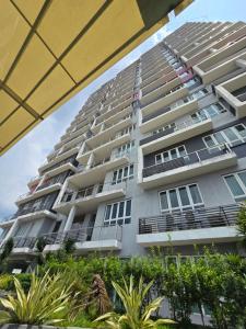 un edificio de apartamentos alto con plantas delante en The Octagon -The City Centre Signature Suite in Ipoh, en Ipoh