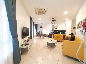 un hombre sentado en un sofá en una sala de estar en The Octagon -The City Centre Signature Suite in Ipoh, en Ipoh