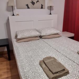 a bed with two towels sitting on top of it at Garden apartment in Karlovo