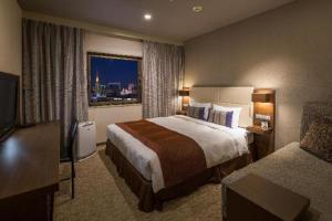 a hotel room with a large bed and a window at Nagoya Sakae Tokyu REI Hotel in Nagoya +60 photos