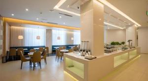 a restaurant with a bar with chairs and tables at Jinjiang Metropolo Hotel Shenyang Country Garden Datong Lake Subway Station Branch in Shenyang