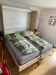 a bed with four pillows on it in a room at Savognin Rundigna in Savognin +3 photos