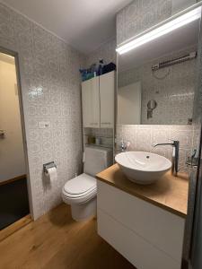 a bathroom with a white sink and a toilet at Savognin Rundigna in Savognin