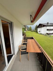 a wooden table and chairs on a balcony at Savognin Rundigna in Savognin