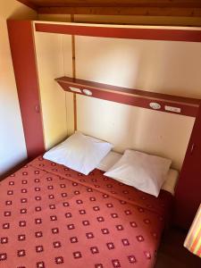 un piccolo letto con due cuscini bianchi di Lagrange Grand Bleu Vacances – Résidence Les Pescalunes ad Agde Altre 25 foto