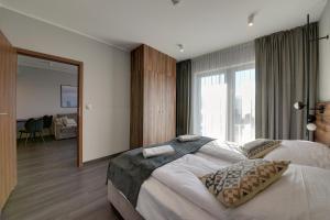 a bedroom with a large bed and a large window at RentPlanet - Apartamenty Karkonoskie in Sosnówka