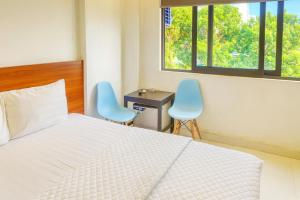 a bedroom with a bed and two blue chairs at YÊN HÒA MOTEL in Hanoi