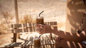 a woman holding two drinks in her hand at Amara Escape in Zuqim +32 photos