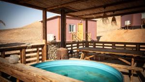 a wooden deck with a hot tub and a table at Amara Escape in Zuqim