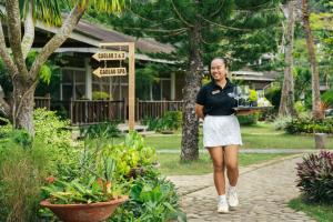 a woman walking down a path holding a tray of desserts at Cadlao Resort and Restaurant in El Nido