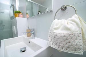 ein Bad mit einem Waschbecken und einem weißen Handtuch in der Unterkunft GREEN HILL Lux Apartments in Sokobanja