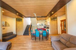 ein Wohnzimmer mit einer Couch und einem Tisch und Stühlen in der Unterkunft Amara Woods Villa in Rāipur