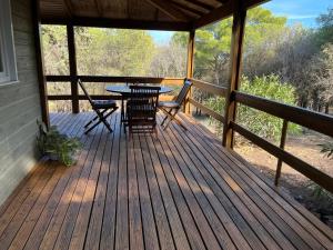 una terrazza in legno con tavolo e sedie. di Lagrange Grand Bleu Vacances – Résidence Les Pescalunes ad Agde