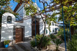 a white house with a wooden door and some plants at Quinta das Virtudes in Funchal