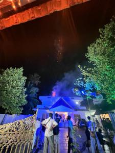 un grupo de personas de pie fuera de una casa por la noche en Haveninn, en Kallana