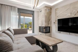 a living room with a couch and a tv and a table at Villa La Caretta in Alikanas