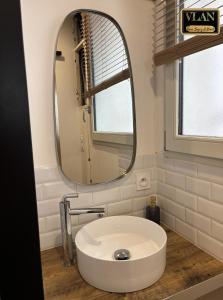 a bathroom with a white sink and a mirror at A l'angle du vieux marché in Niort