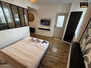 a room with a bed and a tv in it at A l'angle du vieux marché in Niort