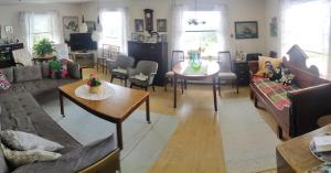 a living room with couches and a table and chairs at Puskan Mummola in Pello