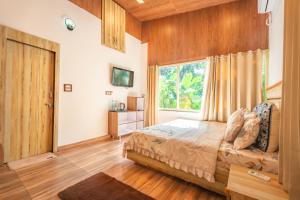 ein Schlafzimmer mit einem Bett und einem großen Fenster in der Unterkunft Amara Woods Villa in Rāipur + 32 Fotos
