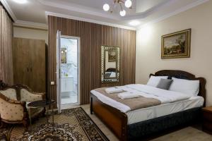 ein Schlafzimmer mit einem Bett, einem Stuhl und einem Spiegel in der Unterkunft Hotel Harmony Premium in Kutaissi + 102 Fotos