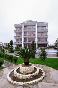 un edificio con una palmera frente a un edificio en Hotel Harmony Premium, en Kutaisi