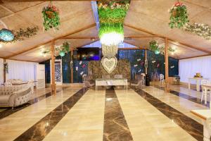 ein großer Saal mit Stühlen, Tischen und Kronleuchtern in der Unterkunft Hotel Harmony Premium in Kutaissi