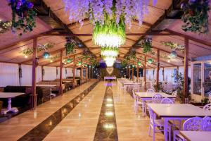 un salón de banquetes con mesas y sillas y una lámpara de araña en Hotel Harmony Premium, en Kutaisi