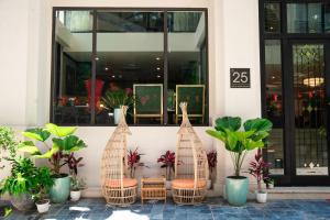 un gruppo di sedie e piante di fronte a un edificio di Nature Hotel - Ba Dinh a Hanoi
