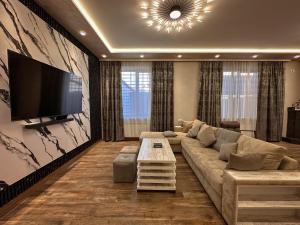 a living room with a couch and a flat screen tv at White Family House in Tsaghkadzor
