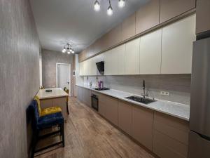 a large kitchen with white cabinets and a blue chair at White Family House in Tsaghkadzor