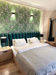 a bedroom with a bed with a green wall at Luxurious apartment in cairo in Cairo