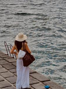 a woman wearing a hat looking at the water at Halgoduria in Santa Marina Salina