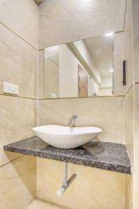 Un baño con un lavabo blanco y un espejo. en Hotel Majestic Pearl, en Nashik