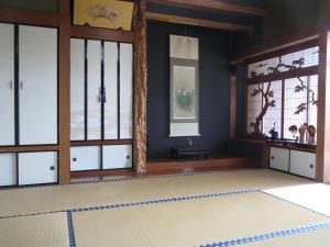 Cette chambre dispose de portes en verre et d'un tapis. dans l'établissement 日田グリーンツーリズム花の木, à Ueda