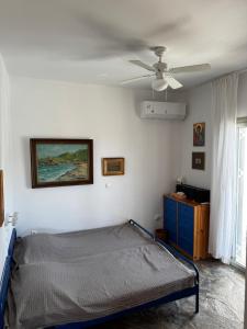 a bedroom with a bed and a ceiling fan at Attica Vacation Home in Dhaskalión