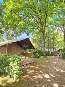 a tent in a park under a tree at Camping Het Veen in Brecht
