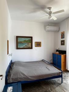DhaskaliónにあるAttica Vacation Homeのベッドと天井扇風機のある寝室