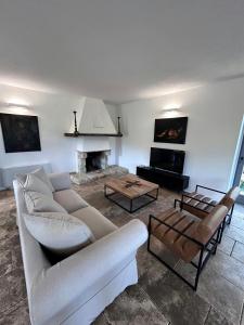 a living room with a couch and a fireplace at Luxury Villa Overlooking Val D'orcia in Roccastrada