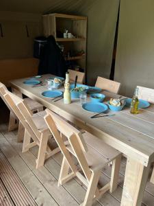 a wooden table with chairs and plates of food on it at Camping Floreal La Roche-en-Ardenne in La Roche-en-Ardenne