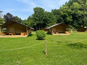 a couple of tents in a field with trees at Camping Floreal La Roche-en-Ardenne in La Roche-en-Ardenne