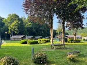 a park with a bench and trees and houses at Camping Floreal La Roche-en-Ardenne in La Roche-en-Ardenne