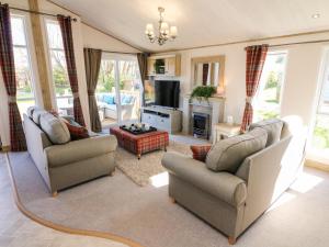 a living room with two chairs and a fireplace at Curlew Lodge in Carnforth