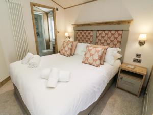 a bedroom with a large white bed with pillows at Curlew Lodge in Carnforth