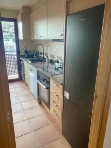 cocina con nevera negra y suelo de baldosa en Especially4u SPA Valley II, en Archena