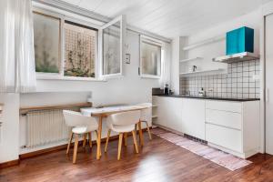 Cornedo all'IsarcoHaus Marlene的厨房配有白色橱柜和木桌及椅子