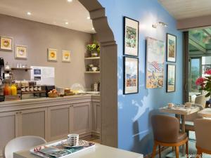 a restaurant with blue walls and tables and a counter at Hotel Daumesnil-Vincennes in Vincennes