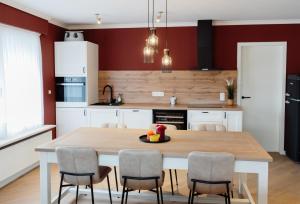 a kitchen with a wooden table and chairs at Casa-Vino in Oostkamp